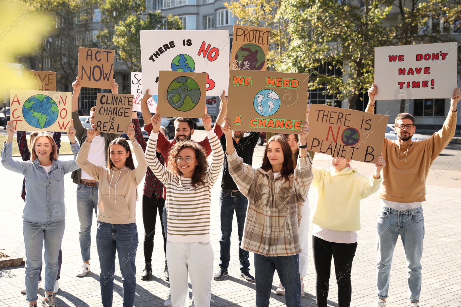 Photo of Group of people with posters protesting against climate change on city street