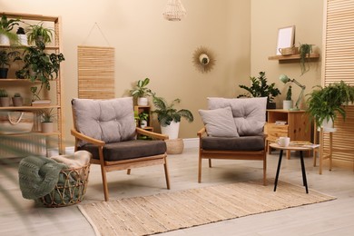 Photo of Lounge area interior with comfortable armchairs and beautiful houseplants