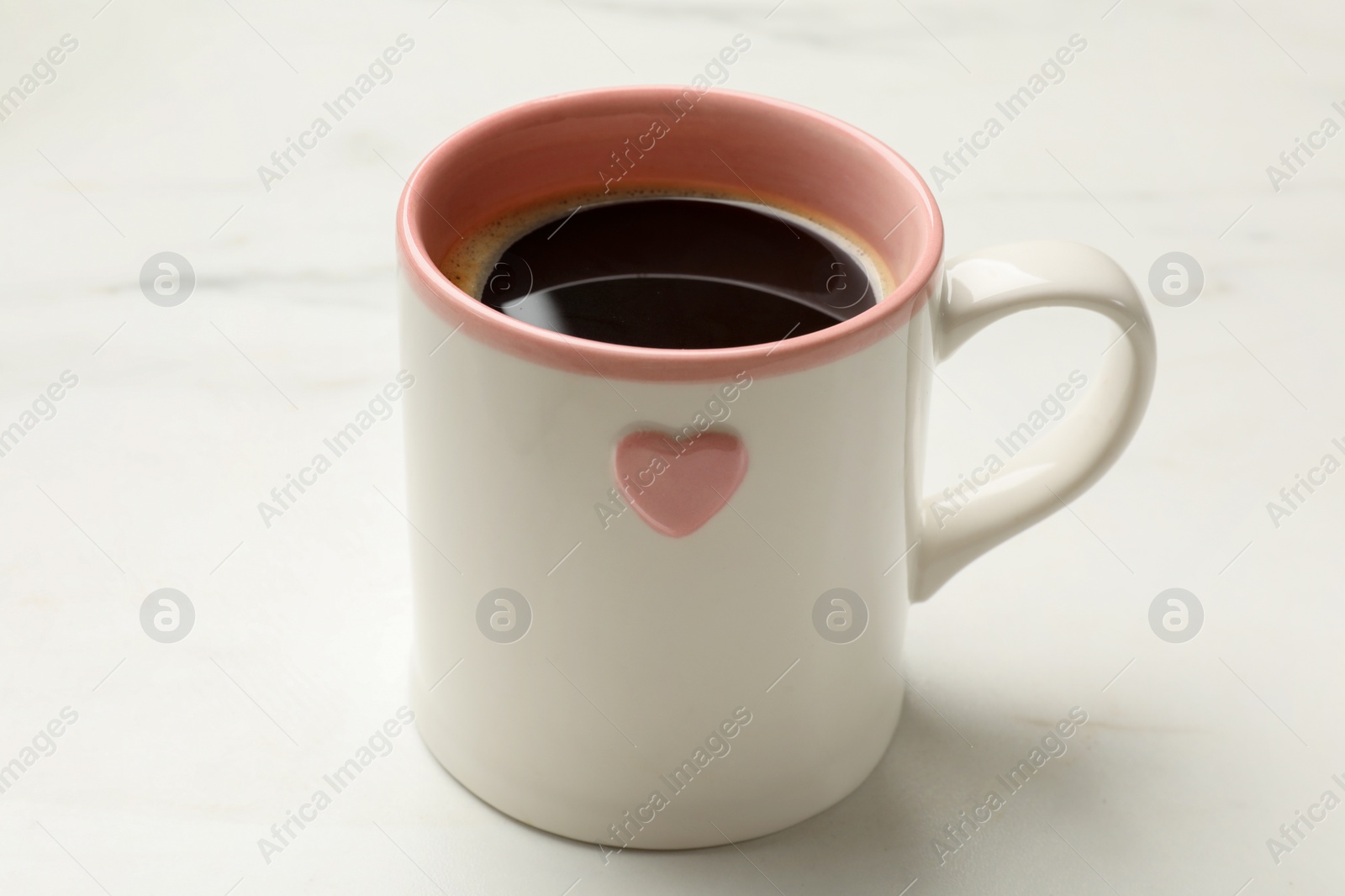 Photo of Cup of aromatic coffee on white table, closeup