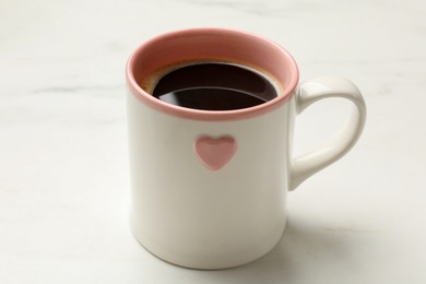 Photo of Cup of aromatic coffee on white table, closeup