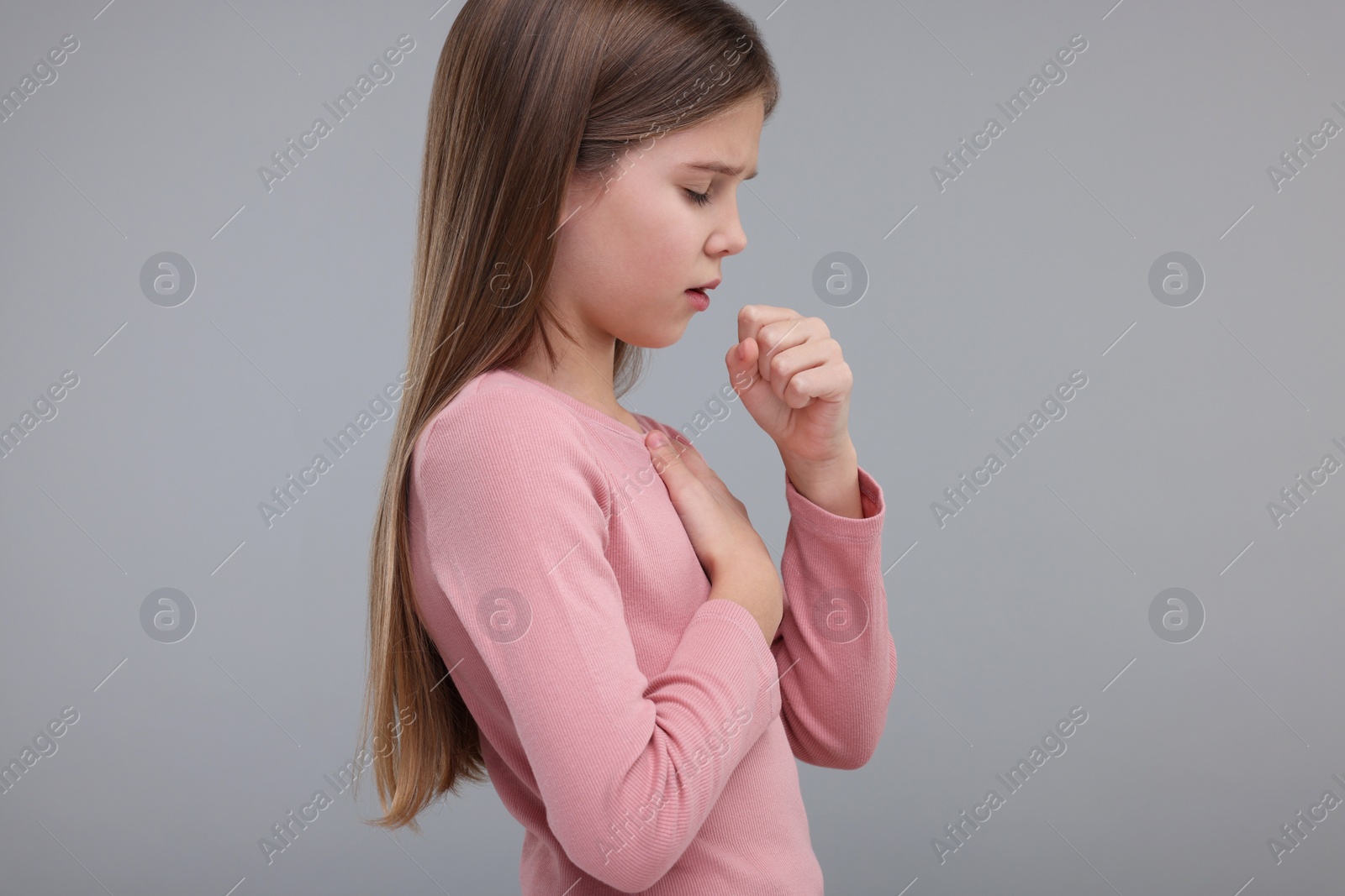 Photo of Sick girl coughing on gray background. Cold symptoms