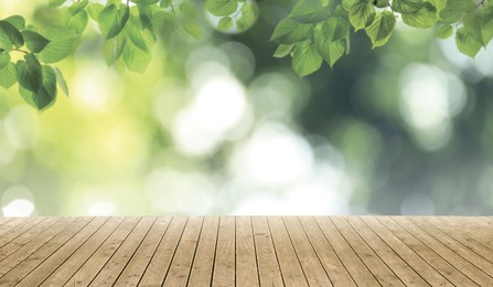 Empty wooden surface and beautiful green leaves on blurred background. Bokeh effect