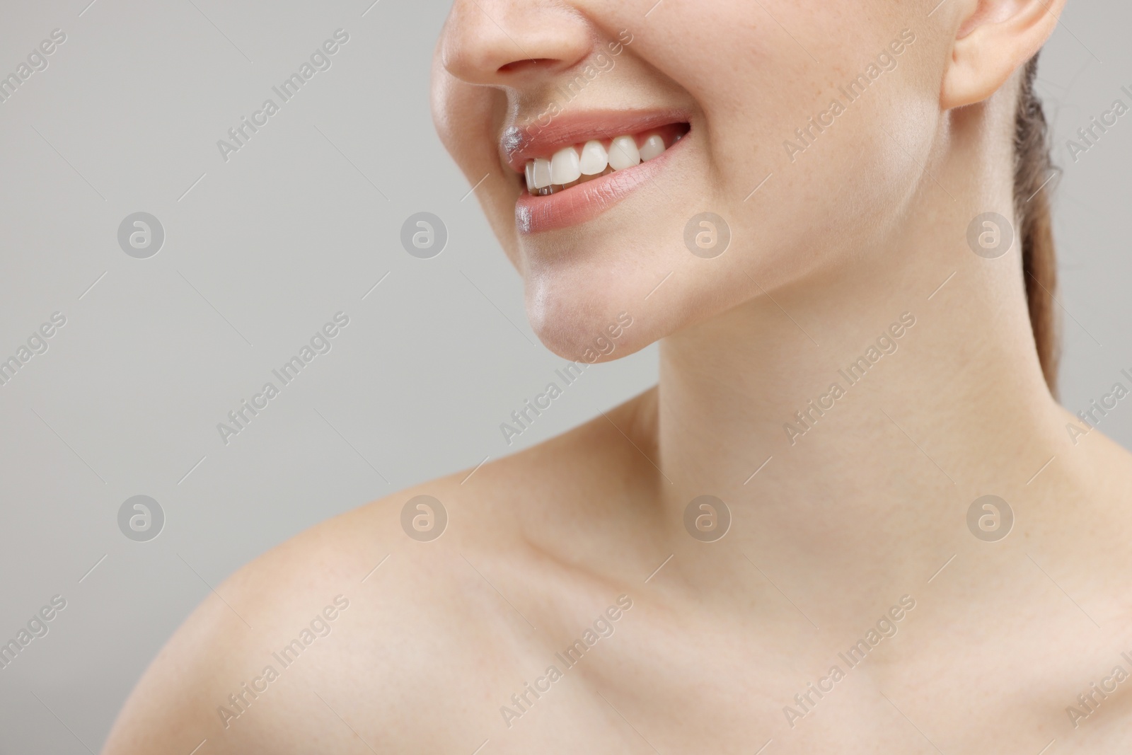 Photo of Beauty concept. Smiling woman on grey background, closeup