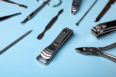 Photo of Set of manicure tools on light blue background, closeup