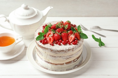 Delicious homemade cake with fresh berries served on wooden table