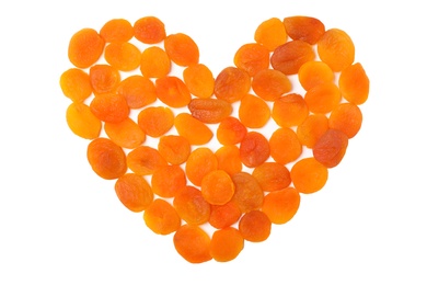 Photo of Heart shaped heap of dried apricots on white background, top view. Healthy fruit