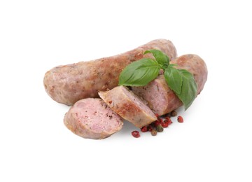 Photo of Tasty whole and cut homemade sausages, peppercorns and basil leaves isolated on white