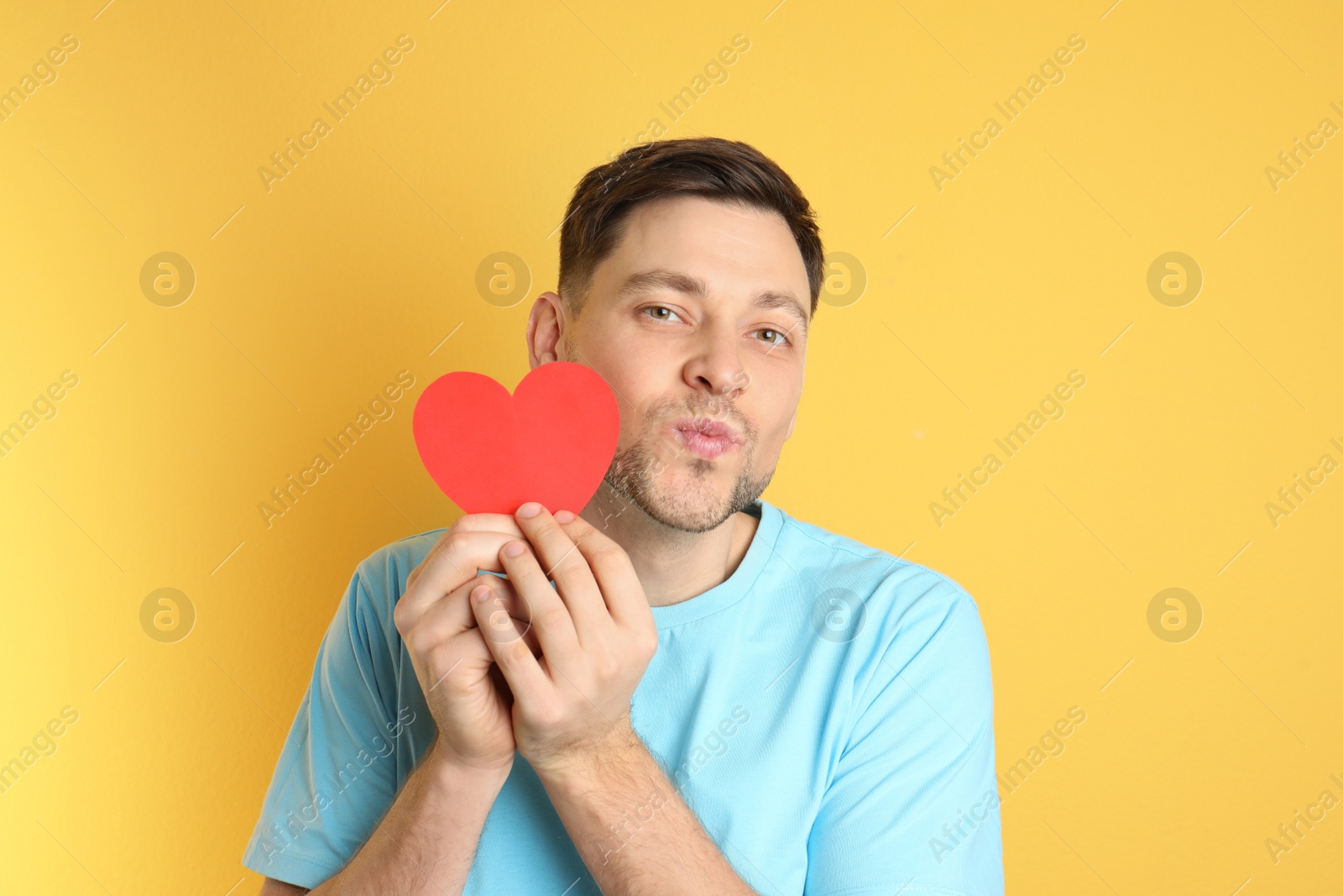 Photo of Portrait of man with paper heart on color background