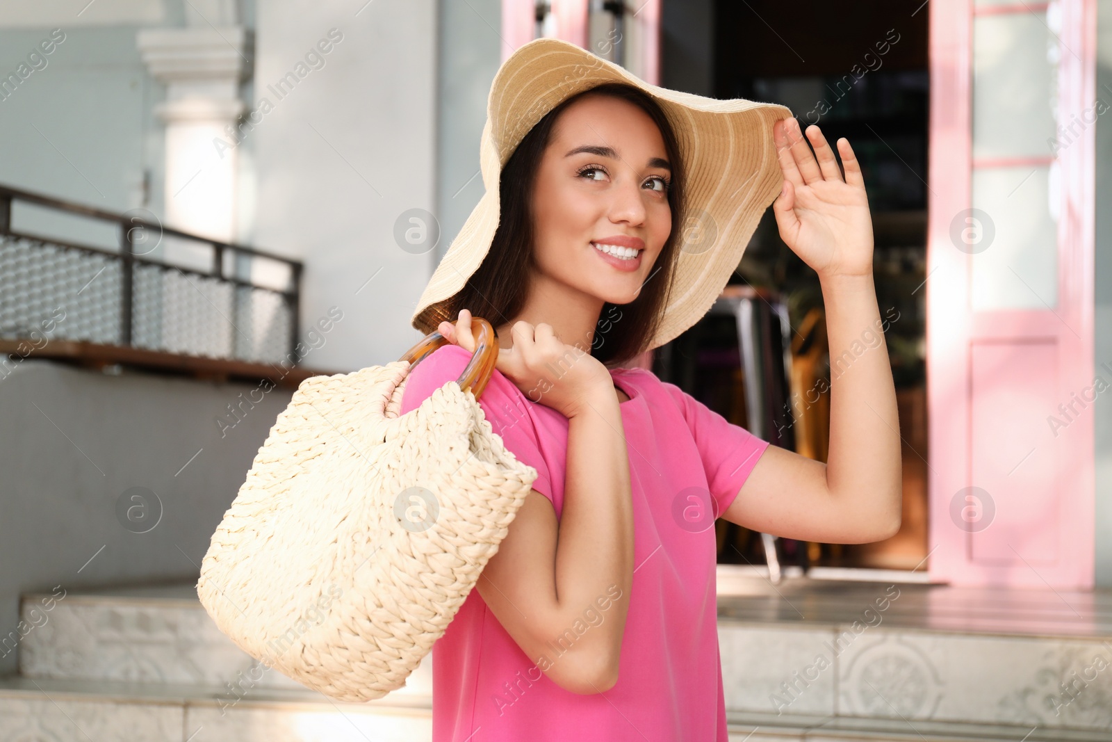 Photo of Young woman with stylish straw bag outdoors