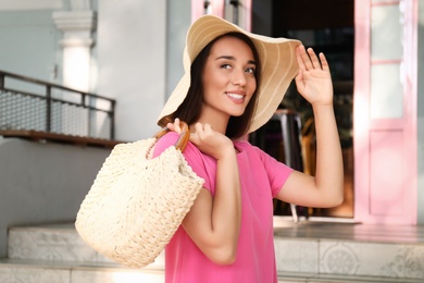 Young woman with stylish straw bag outdoors