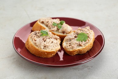 Photo of Tasty sandwiches with cod liver on light grey table