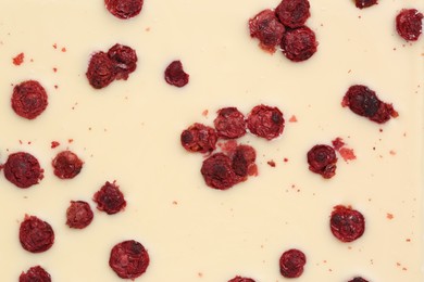 Photo of Chocolate bar with freeze dried red currants as background, closeup