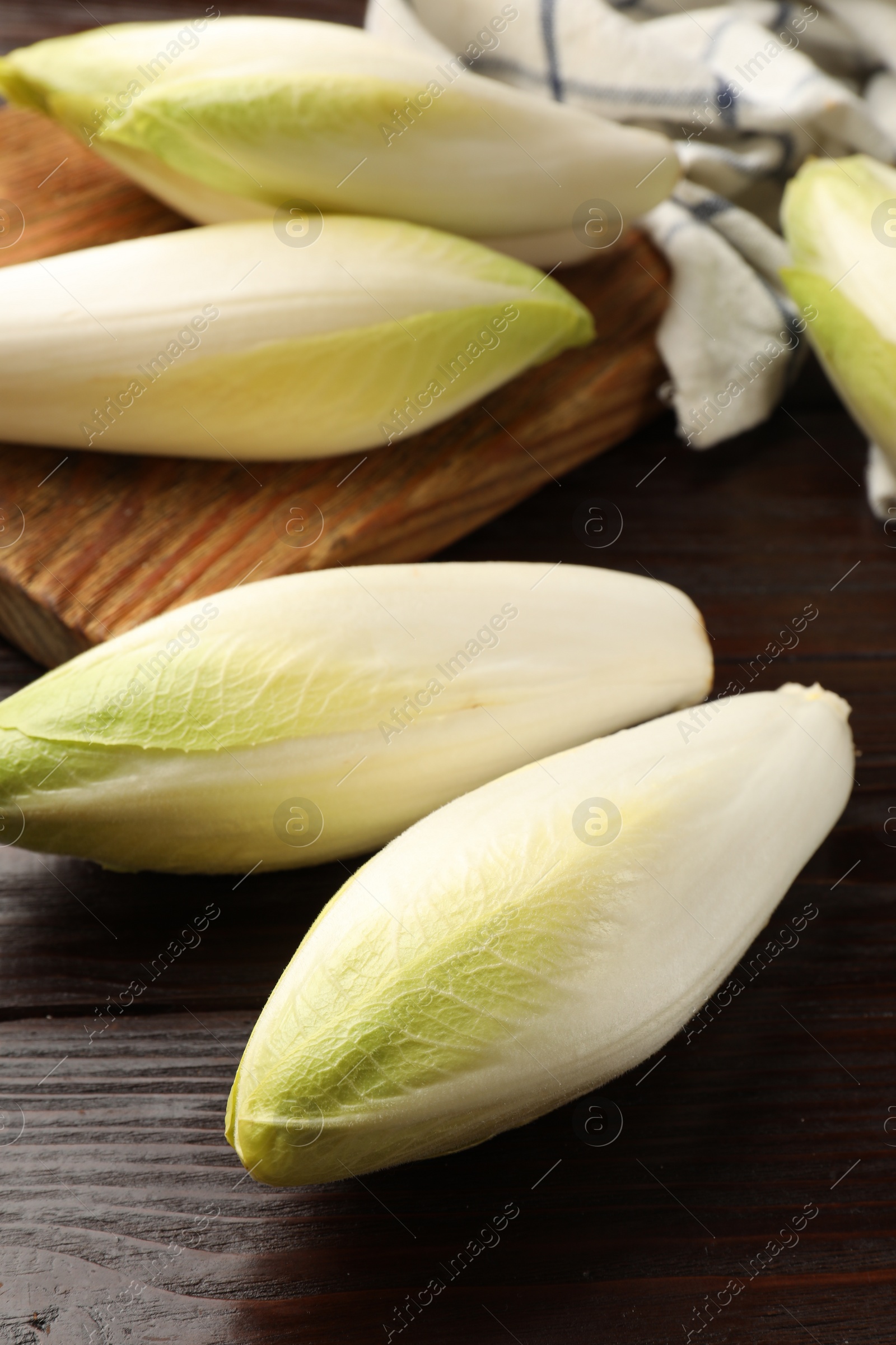 Photo of Raw ripe chicories on wooden table, closeup