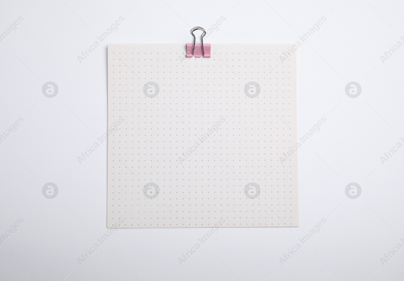 Photo of Sheet of paper with clip on white background, top view