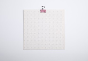 Sheet of paper with clip on white background, top view