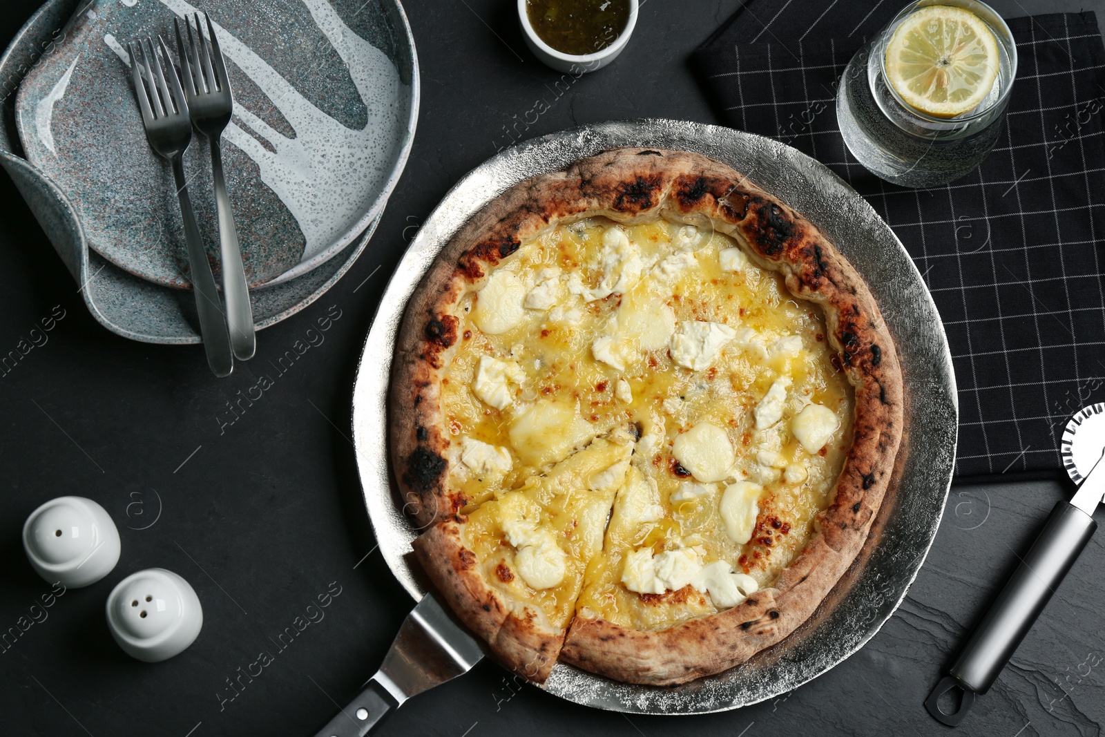 Photo of Tasty cheese pizza served on black table, flat lay