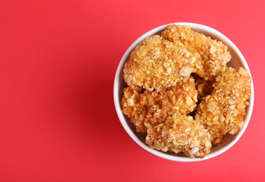 Bucket with yummy nuggets on pink background, top view. Space for text