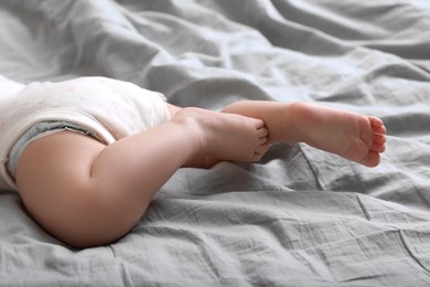 Photo of Little baby lying on bed, closeup view