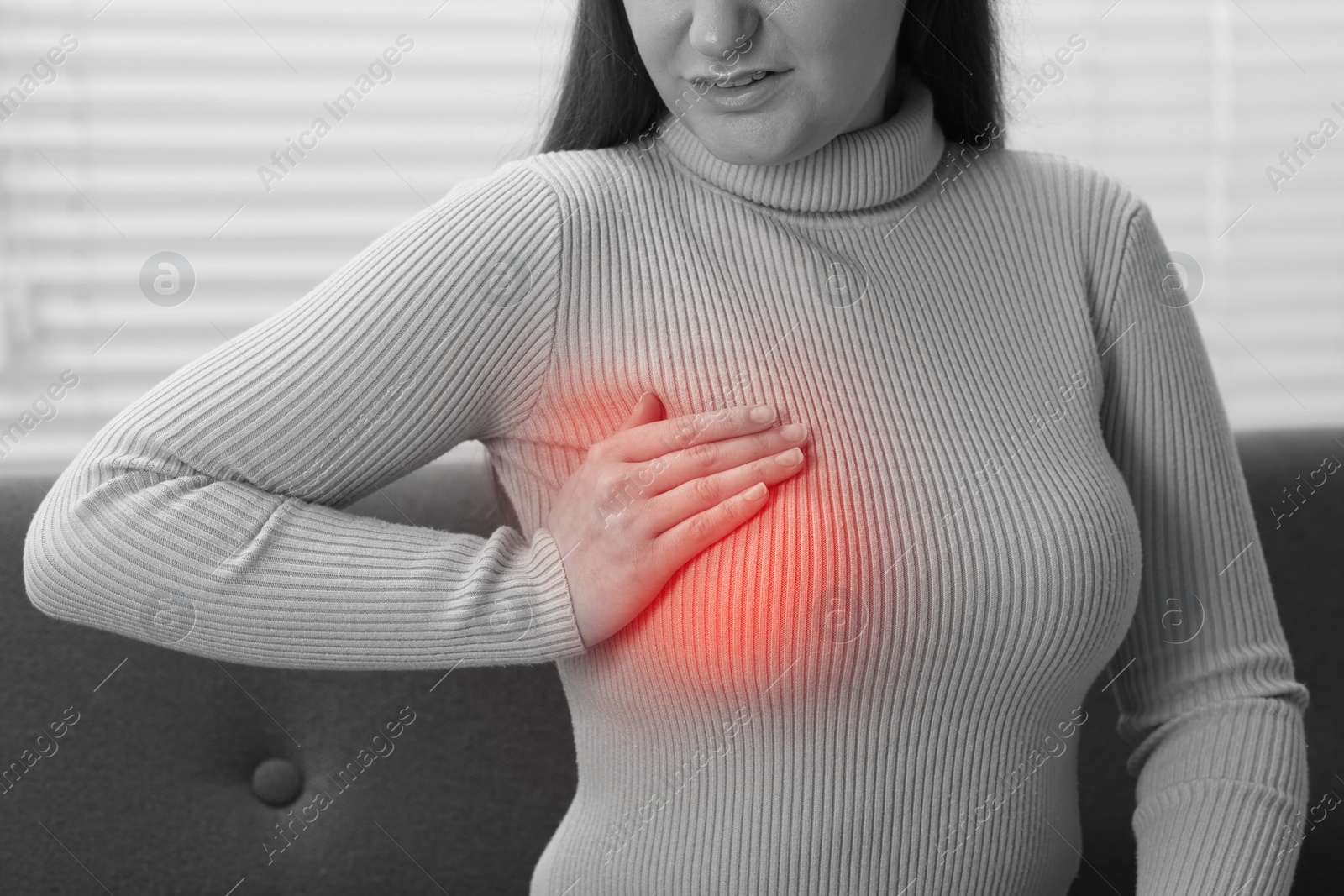 Image of Young woman suffering from breast pain at home, closeup. Black and white with color accent effect