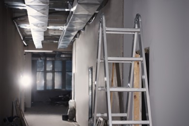 Photo of Metal ladder and building materials in hall prepared for renovation