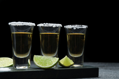 Mexican Tequila shots with lime slices and salt on table