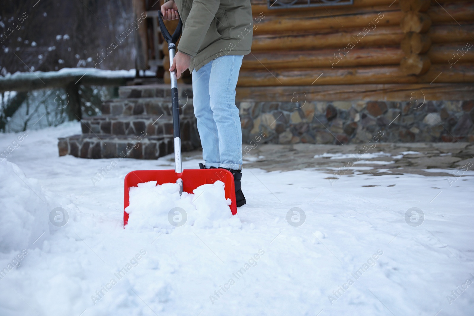 Photo of Man cleaning snow with shovel outdoors on winter day, closeup