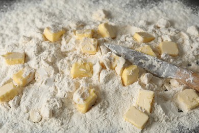 Photo of Making shortcrust pastry. Flour, butter and knife on table, closeup