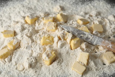 Making shortcrust pastry. Flour, butter and knife on table, closeup