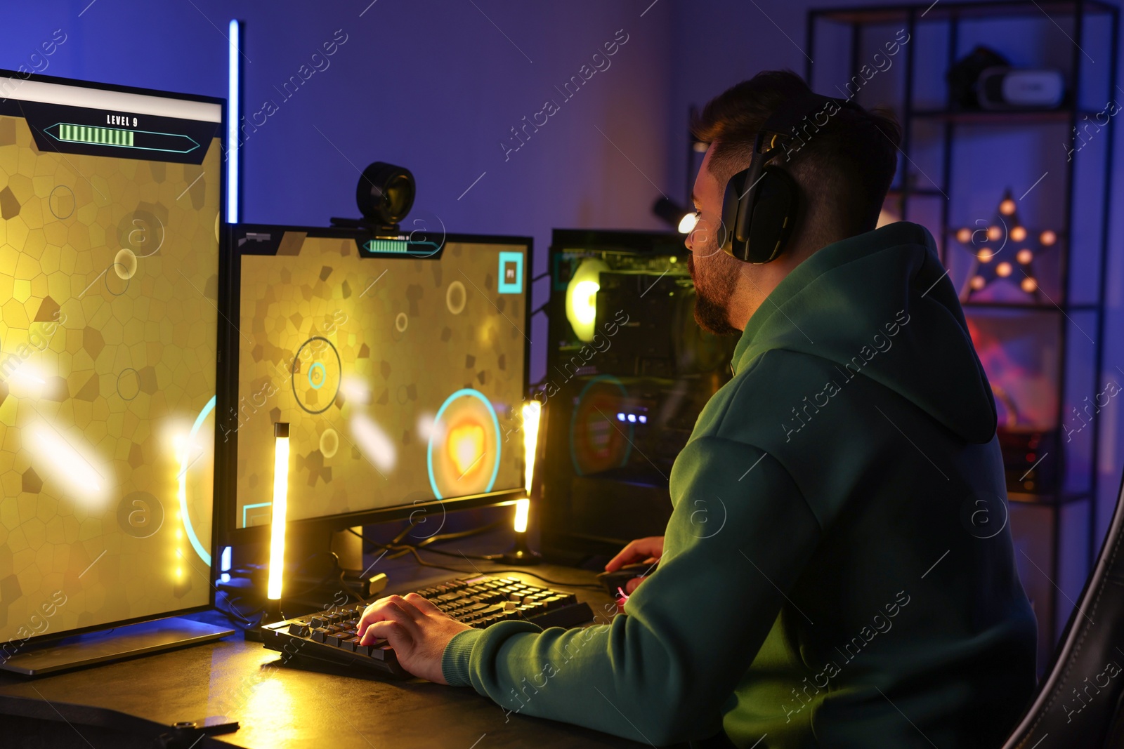 Photo of Man playing video games on computer at table indoors