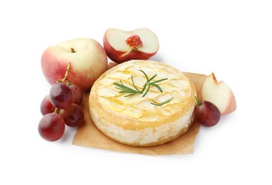 Tasty baked brie cheese with rosemary, grapes and peaches isolated on white