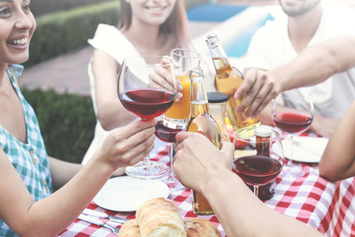 Image of Happy friends with drinks having fun at barbecue party outdoors, closeup
