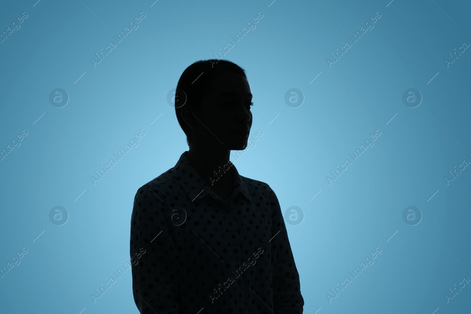 Photo of Silhouette of anonymous woman on light blue background