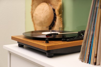 Photo of Turntable with vinyl record on white table indoors, space for text
