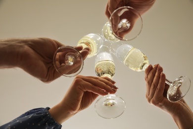 People clinking glasses of champagne indoors, closeup
