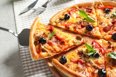 Delicious pizza with olives and sausages on table