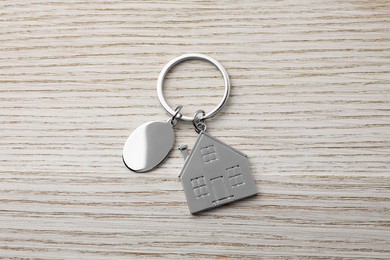 Metallic keychains with key ring on light wooden background, top view