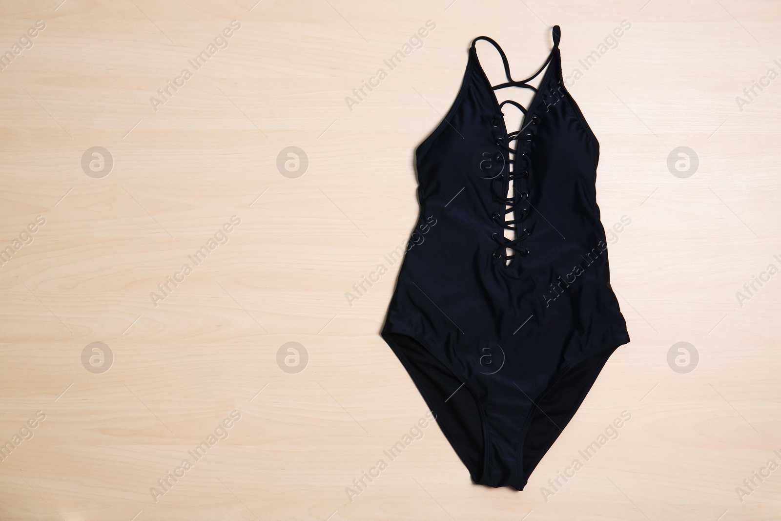 Photo of Beautiful swimsuit on wooden background, top view