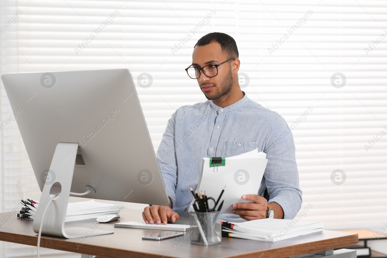 Photo of Businessman working with documents at wooden table in office