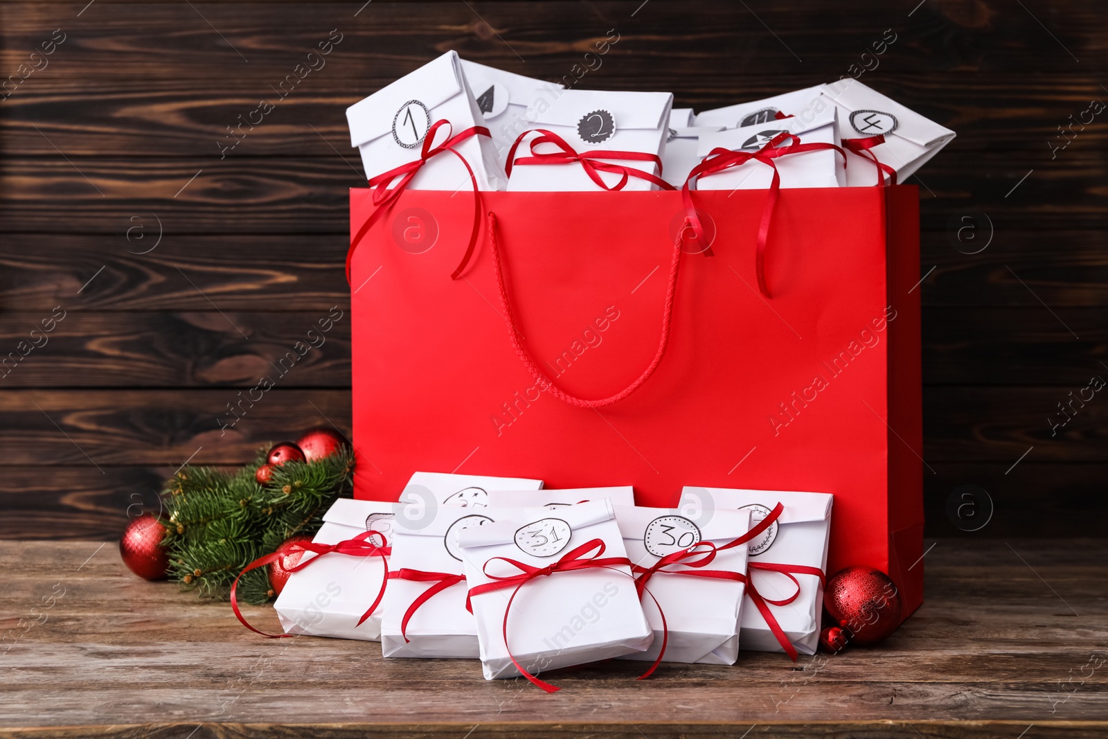 Photo of Set of gifts and Christmas decor on wooden table. New Year advent calendar