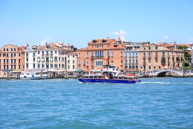 VENICE, ITALY - JUNE 13, 2019: Picturesque view of city on sea shore and boats