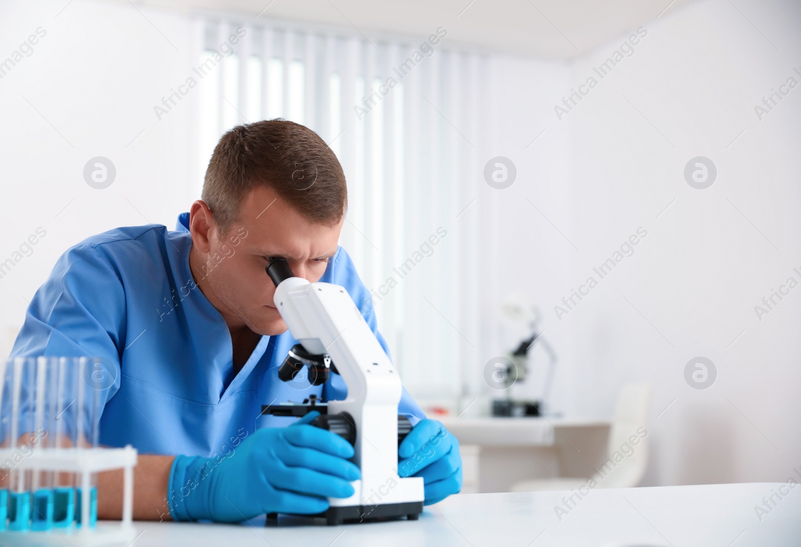 Photo of Scientist using modern microscope at table. Medical research