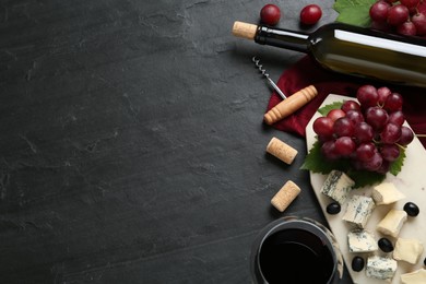 Photo of Tasty red wine and snacks on black table, flat lay. Space for text