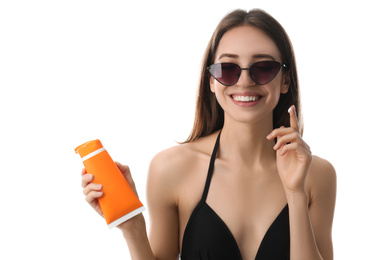 Photo of Young woman applying sun protection cream on white background