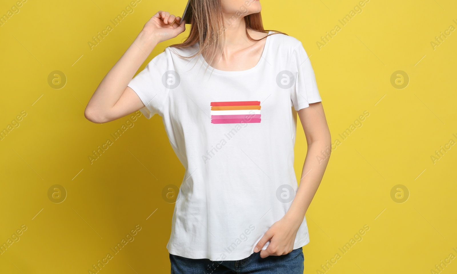 Image of Young woman wearing white t-shirt with lesbian flag on yellow background. LGBT concept