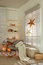 Photo of Beautiful decorative stars and festive lights in room. Christmas atmosphere