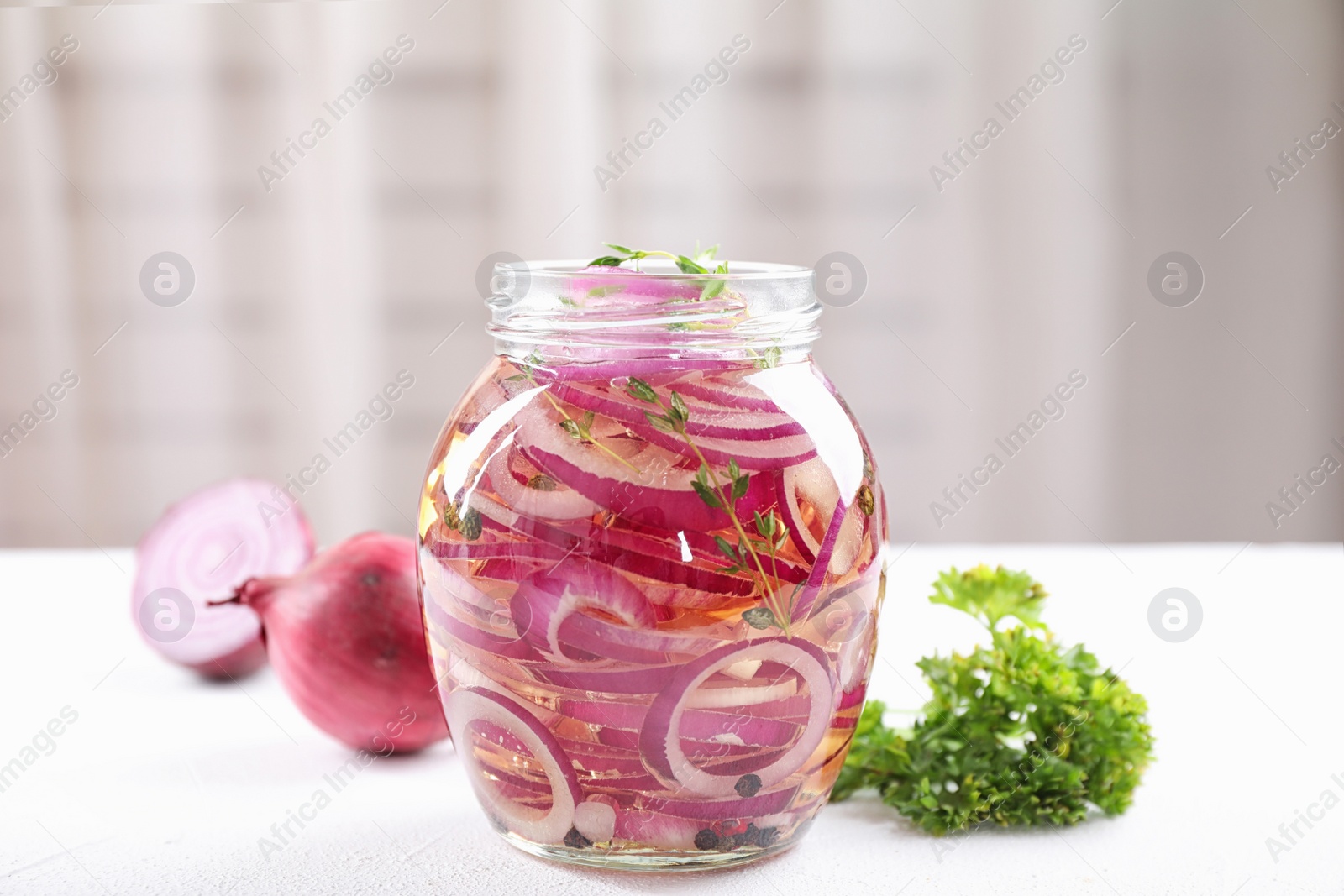 Photo of Jar of pickled onions on white table