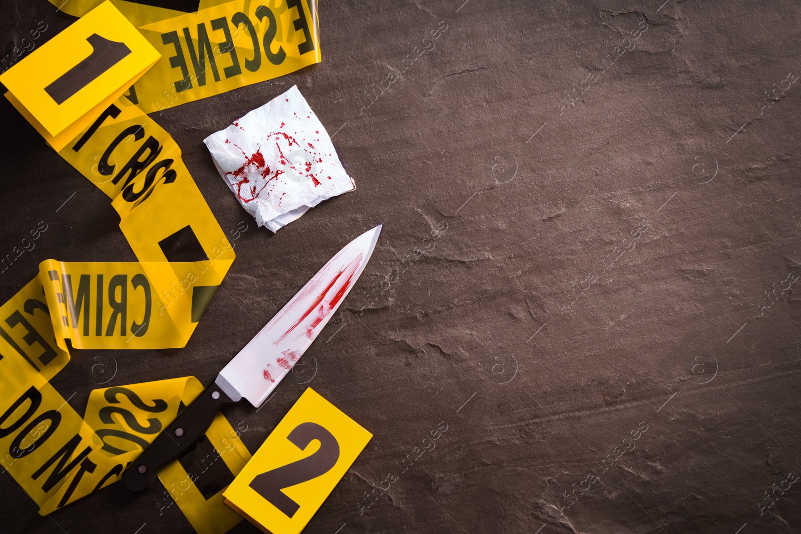 Photo of Flat lay composition with evidences on black slate background, space for text. Crime scene