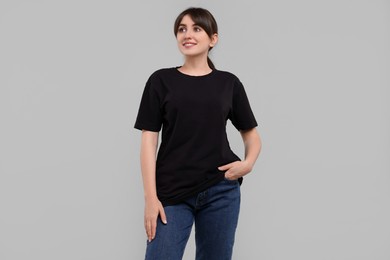 Photo of Smiling woman in stylish black t-shirt on light grey background