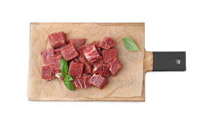 Photo of Wooden board with cut fresh beef meat and basil leaves isolated on white, top view