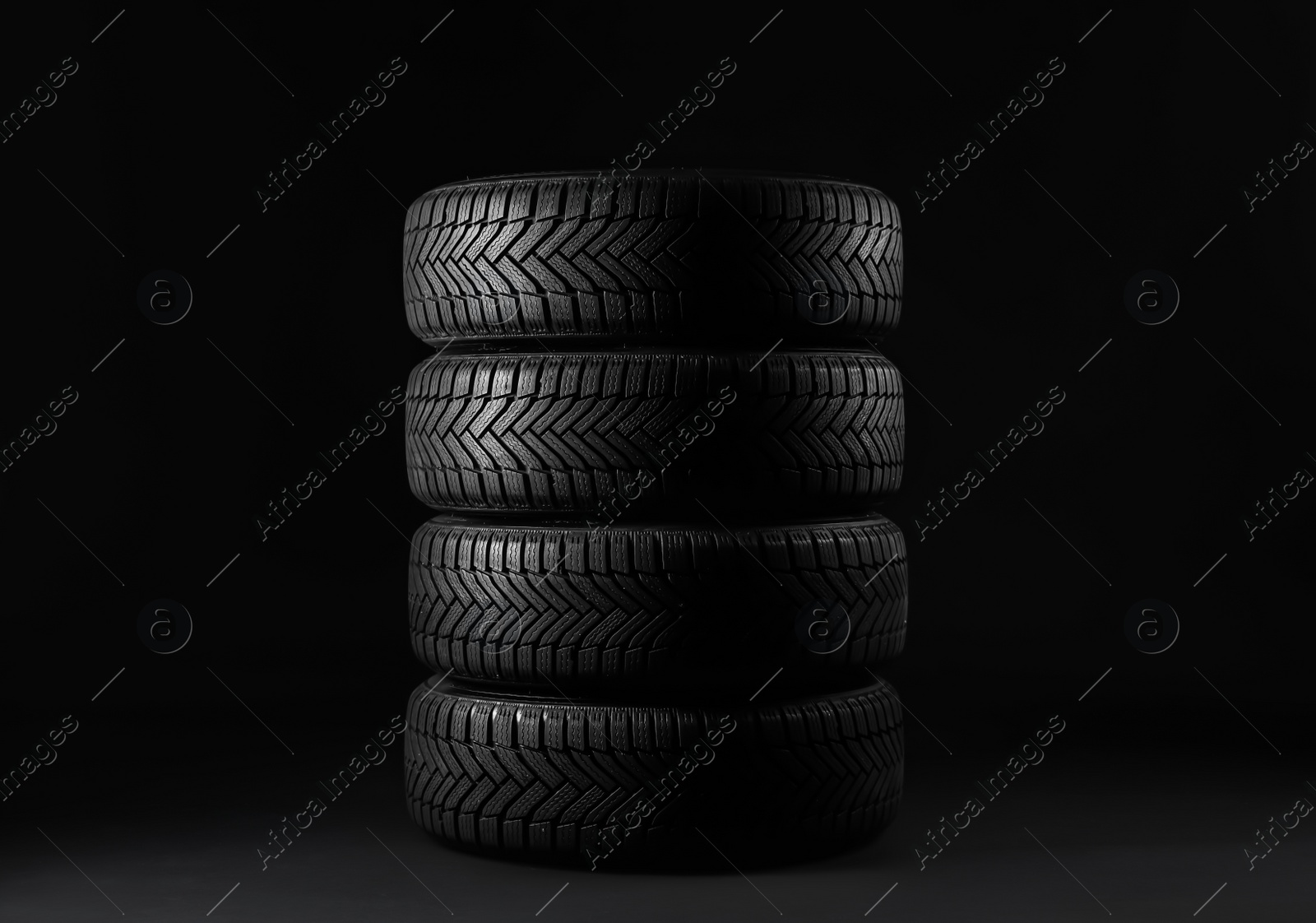 Photo of Set of new winter tires on black background